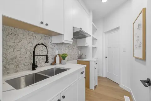 The spice kitchen behind the main kitchen. Furniture and décor are staging for the photos.